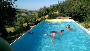 Una piscina rectangular con vistas a un paisaje montañoso.