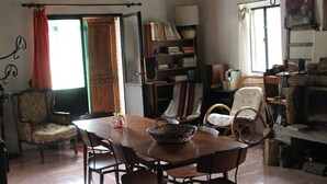 Un comedor con una mesa de madera, sillas, una cesta y una estantería.
