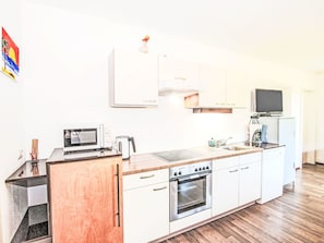 Mikrobølgeovn, ovn, oppvaskmaskin og høy barnestol