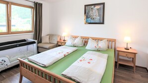 A hotel room with a bed, a sofa, a window, and a painting on the wall. - Nice apartment for 4 guests with WIFI, TV and patio (Helfenstein)