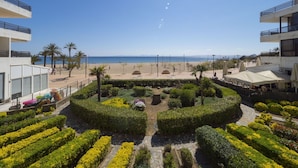 A beachfront view with a circular garden, a beach, and a clear sky. - Amazing apartment on the seafront in Roses Inmosantos Oasis D4 (Rosas / Roses)