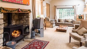 A cozy living room with a stone fireplace, a television, and comfortable seating.
