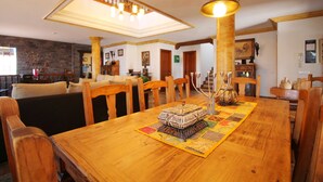 Un comedor con una mesa de madera, sillas y un adorno central.