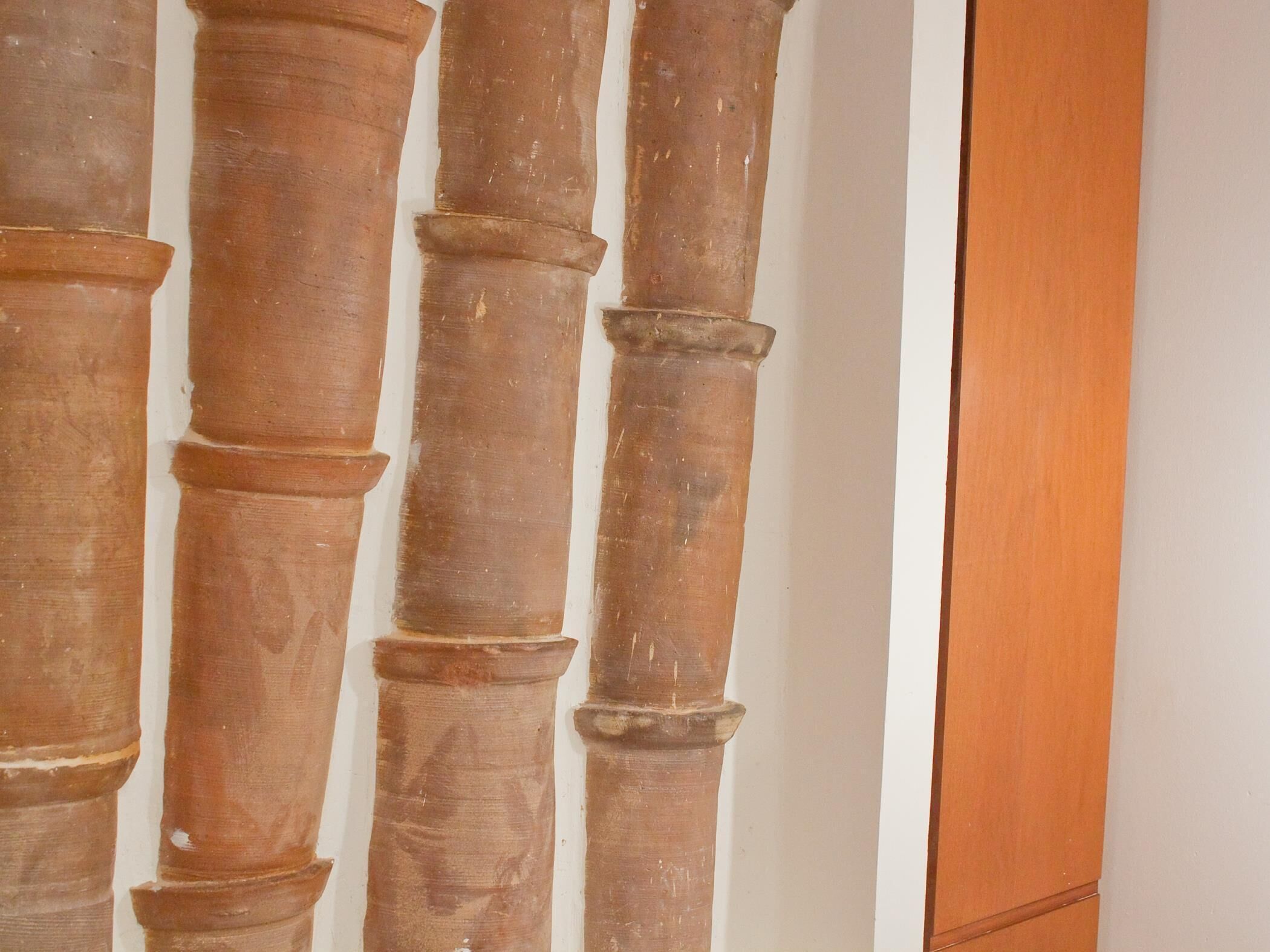 A close-up of a column with a textured surface, likely made of wood or stone.