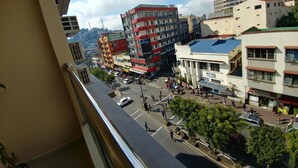 Un paisaje urbano con varios edificios, incluyendo una estructura de varios pisos con fachada roja y blanca y un edificio grande y colorido con una cúpula.