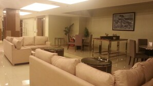 Una sala de estar moderna con un conjunto de sofás, una mesa de comedor con sillas y una pequeña mesa auxiliar.