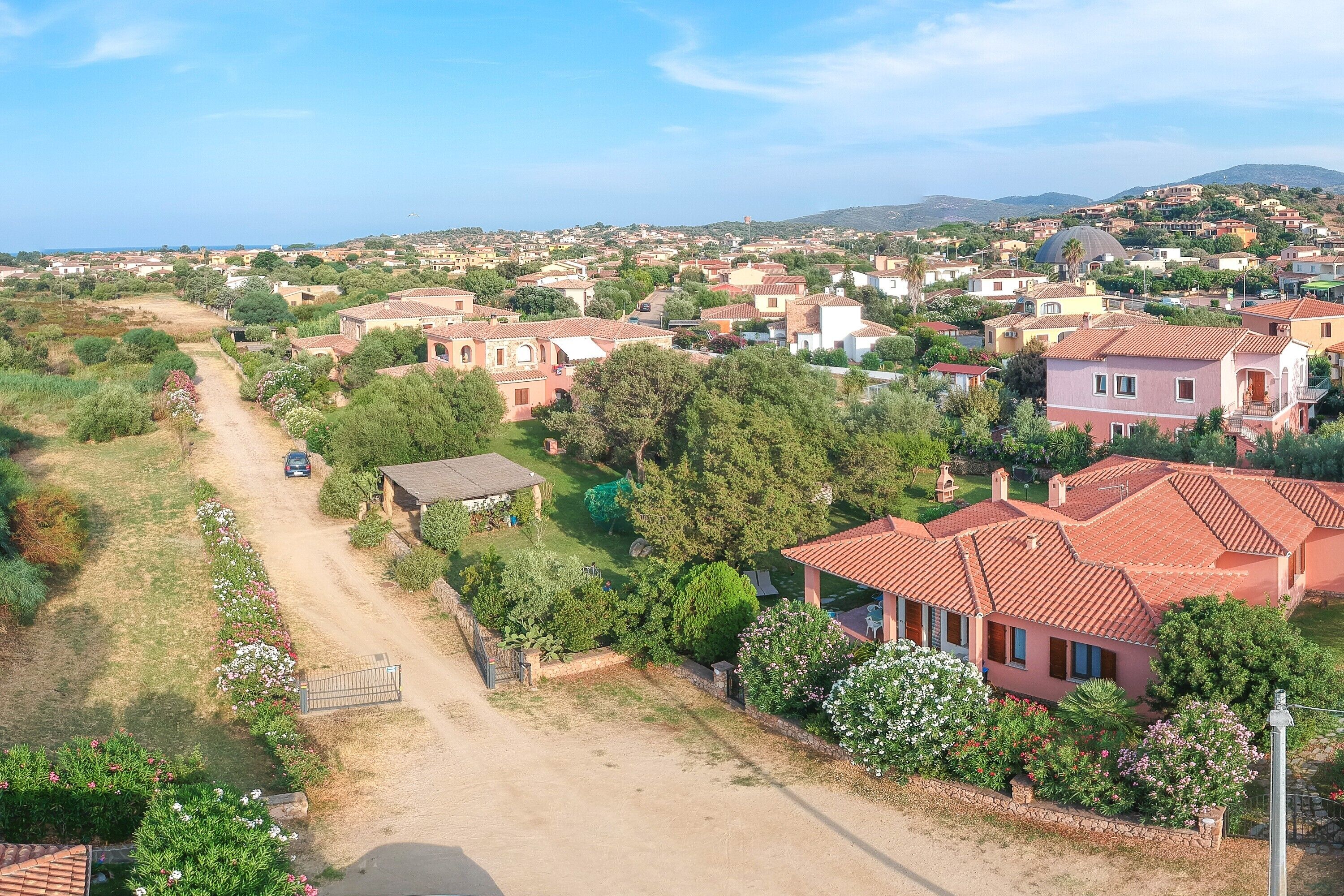 Un quartier résidentiel avec des maisons, un chemin de terre et une route.