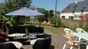 An outdoor deck with wicker furniture, a table, and a patio umbrella.