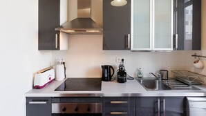 A modern kitchen with a built-in stove, a kettle, a toaster, and a sink. - Bessons-1884-Bourgeois style apartment with large terrace (Cannes)