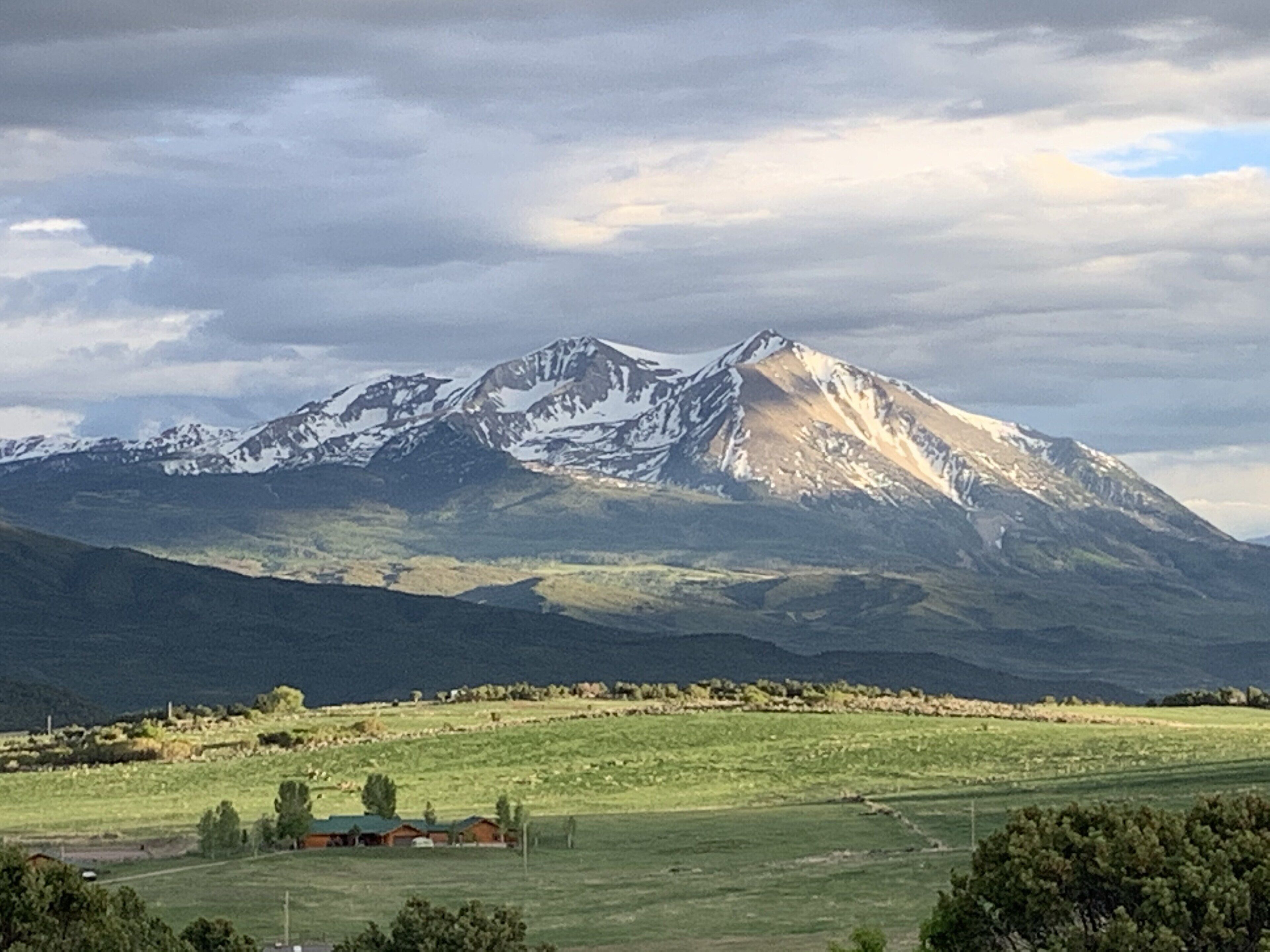 A mountain landscape with a small settlement in the foreground.