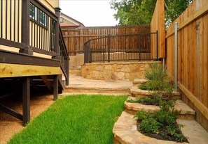Enjoy the serene atmosphere of this beautifully maintained outdoor space with a wooden deck and stone staircase.