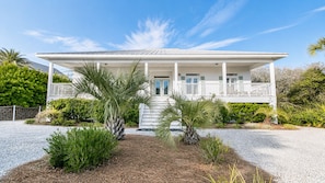 A two-story house with a covered porch, a gravel driveway, and various tropical plants. - 92 Reviews, 10-Star ☀️ 1 House from Gulf | Private Beach | Beach Gear | 5200 SF | 6BR ☀️ 30A (Santa Rosa Beach)