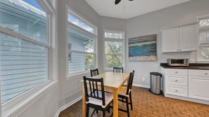 Kitchen features a dining table, sink, microwave, and cabinetry.