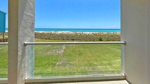 A view from a window overlooking a beach with a clear sky.