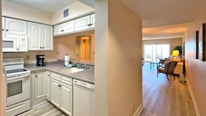 A modern kitchen with white cabinets, a built-in oven, and a dishwasher.