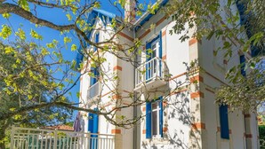 A two-story building with a balcony and a small garden area. - Beautiful private villa for 10 guests with WIFI, TV and terrace (Saint-palais-sur-mer)