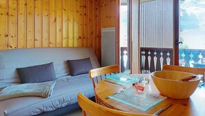 A wooden cabin interior with a sofa, dining table, and chairs. - Beautiful apartment for 3 guests with WIFI, TV, balcony and pets allowed (Saint-gervais-les-bains)