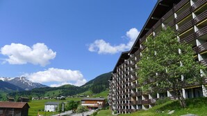 Un hotel de diseño moderno, situado en una zona montañosa con cielo despejado.