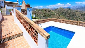 A rooftop pool with a view of a mountainous landscape.