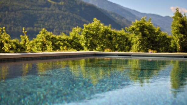 Una piscina cristalina con montañas al fondo.