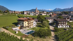 Zona residencial con una iglesia destacada, una piscina y un viñedo.