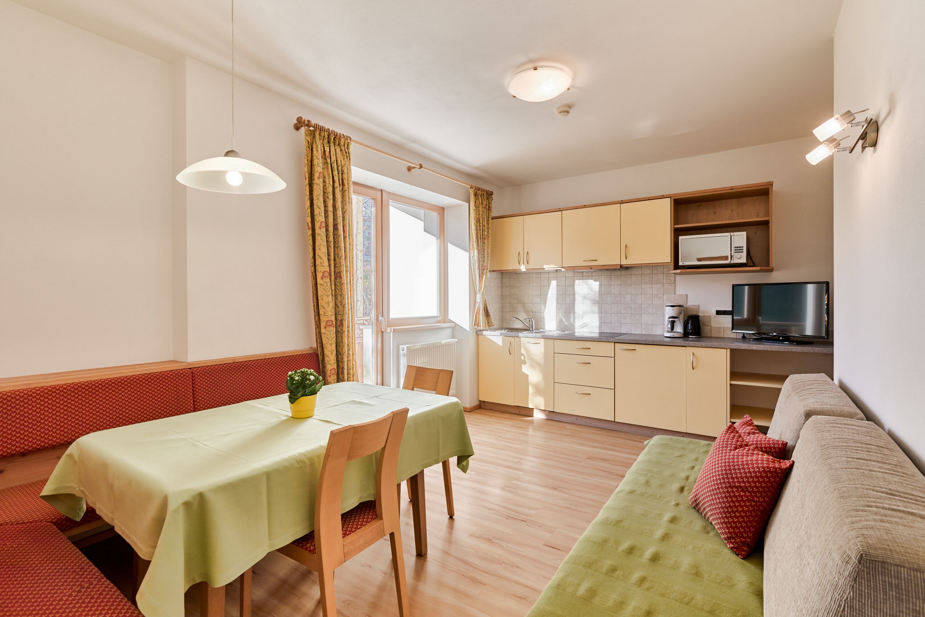 A compact living space with a dining area, kitchenette, and seating area.