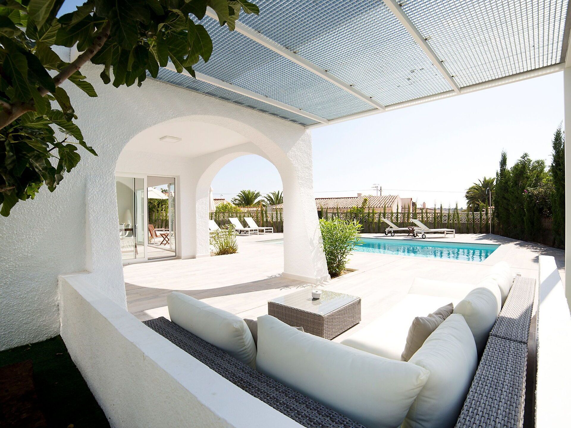 A modern outdoor pool area with a covered seating area and lounge chairs.