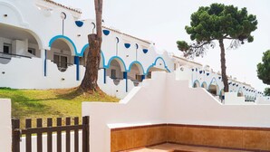 Un bâtiment blanc agrémenté de touches de bleu et entouré d’une clôture en bois.