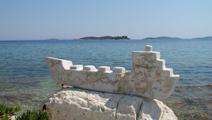 A model ship on a rock by the sea.