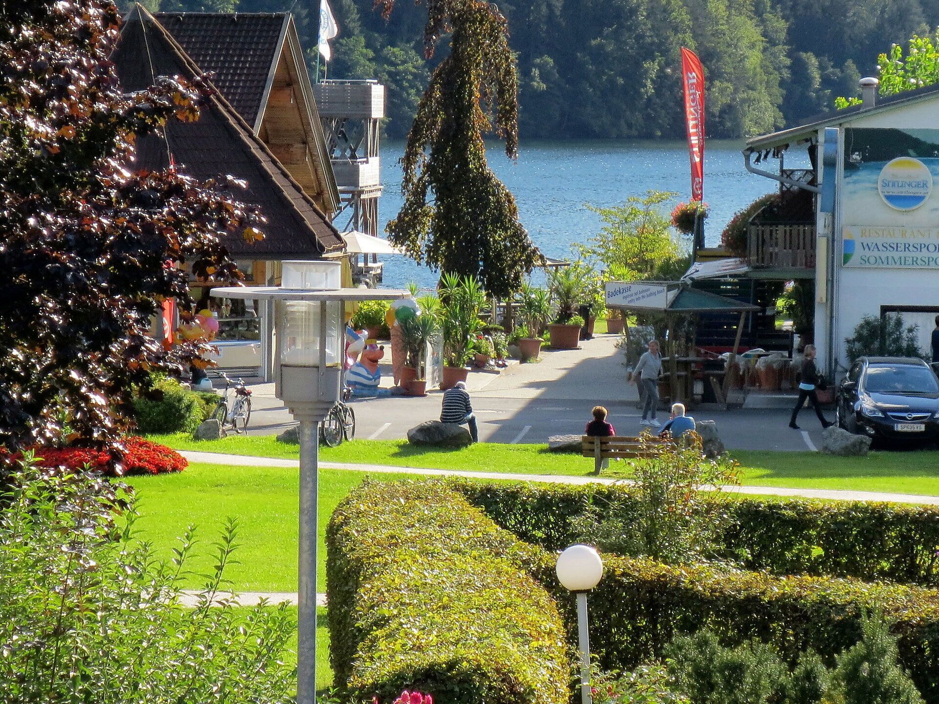 A lakeside restaurant with outdoor seating and a view of the lake.