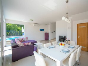 Relax in this stylish space with a central dining area for four, a comfortable sofa, and a flat-screen TV.