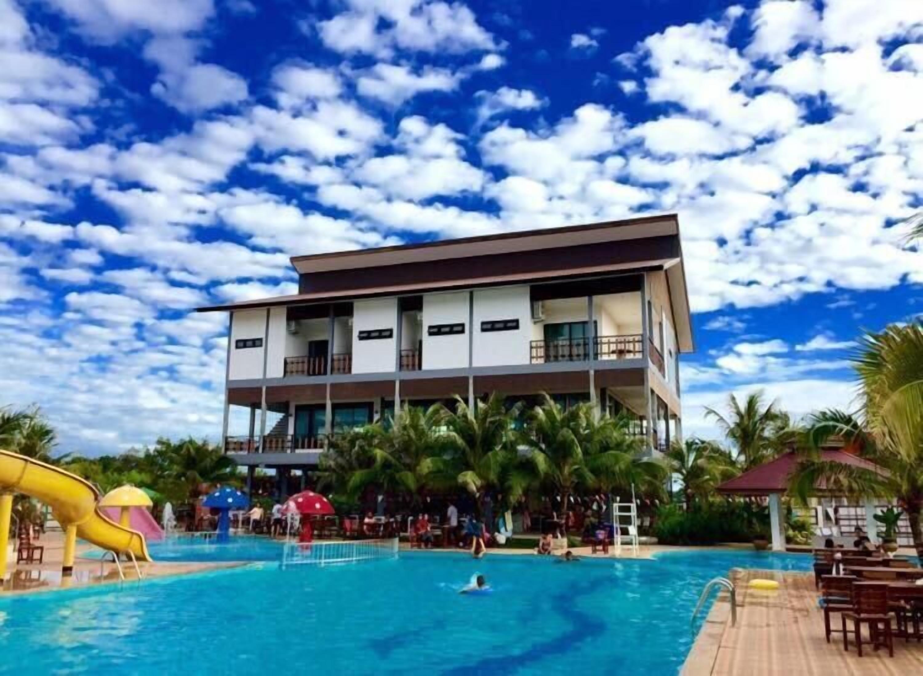 Ein modernes Hotel mit Poolbereich, inklusive Wasserrutsche und Liegestühlen.
