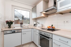 Mikrobølgeovn, ovn, oppvaskmaskin og høy barnestol