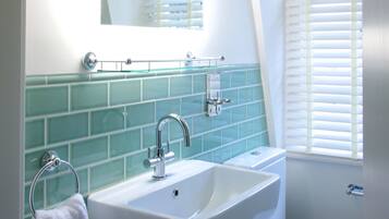 A bathroom with a white sink, a mirror, and a toilet.
