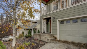 Ein zweistöckiges Haus mit Garage, einer Veranda und einer Auffahrt.