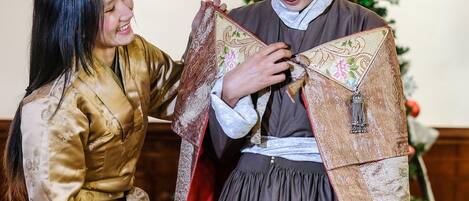 Una persona in abiti tradizionali che riceve assistenza da un'altra persona.