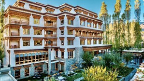 A multi-story hotel with a traditional architectural style, featuring balconies and large windows. - The Indus Valley (Leh)