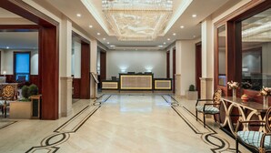 A spacious lobby with a marble floor, a reception desk, and a chandelier. - The Indus Valley (Leh)