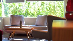 A modern living room with a sofa, a small table, and a vase.