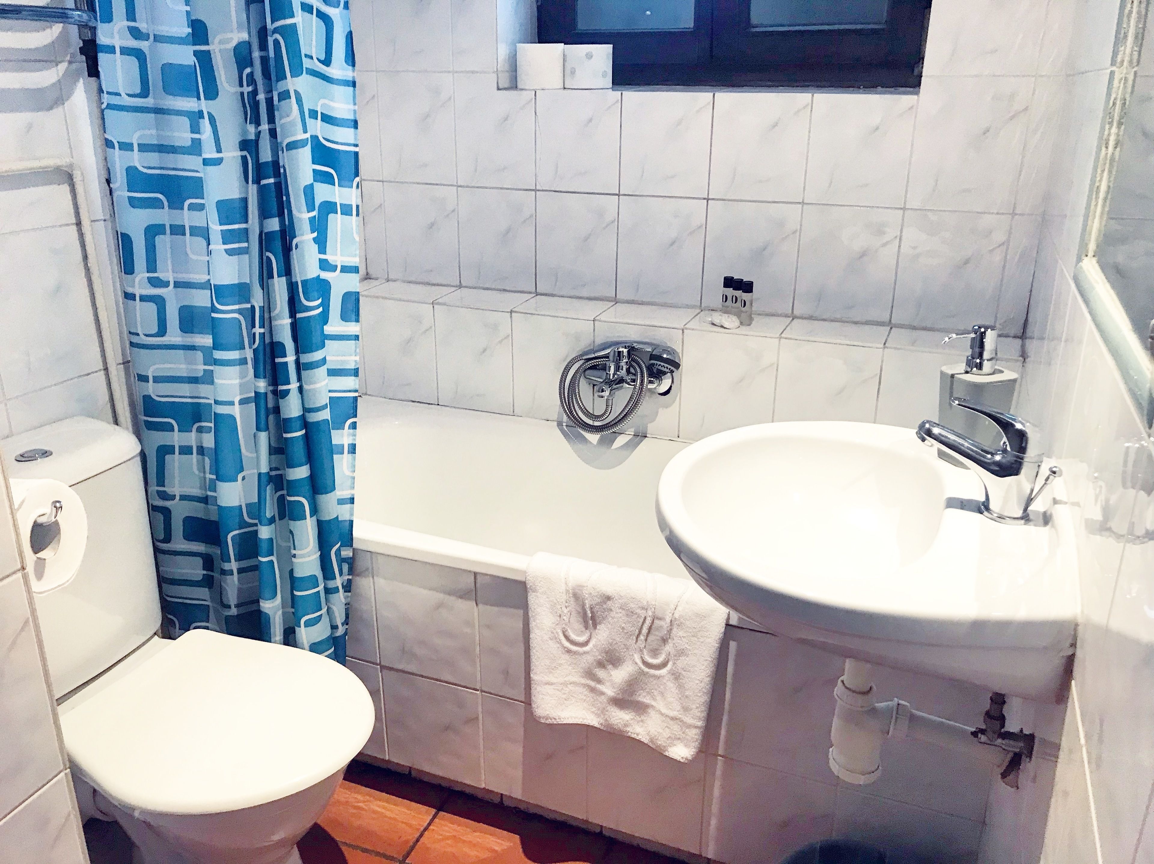 A bathroom with a toilet, a bathtub, and a sink.