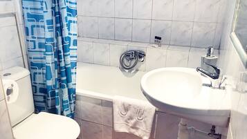 A bathroom with a toilet, a bathtub, and a sink.