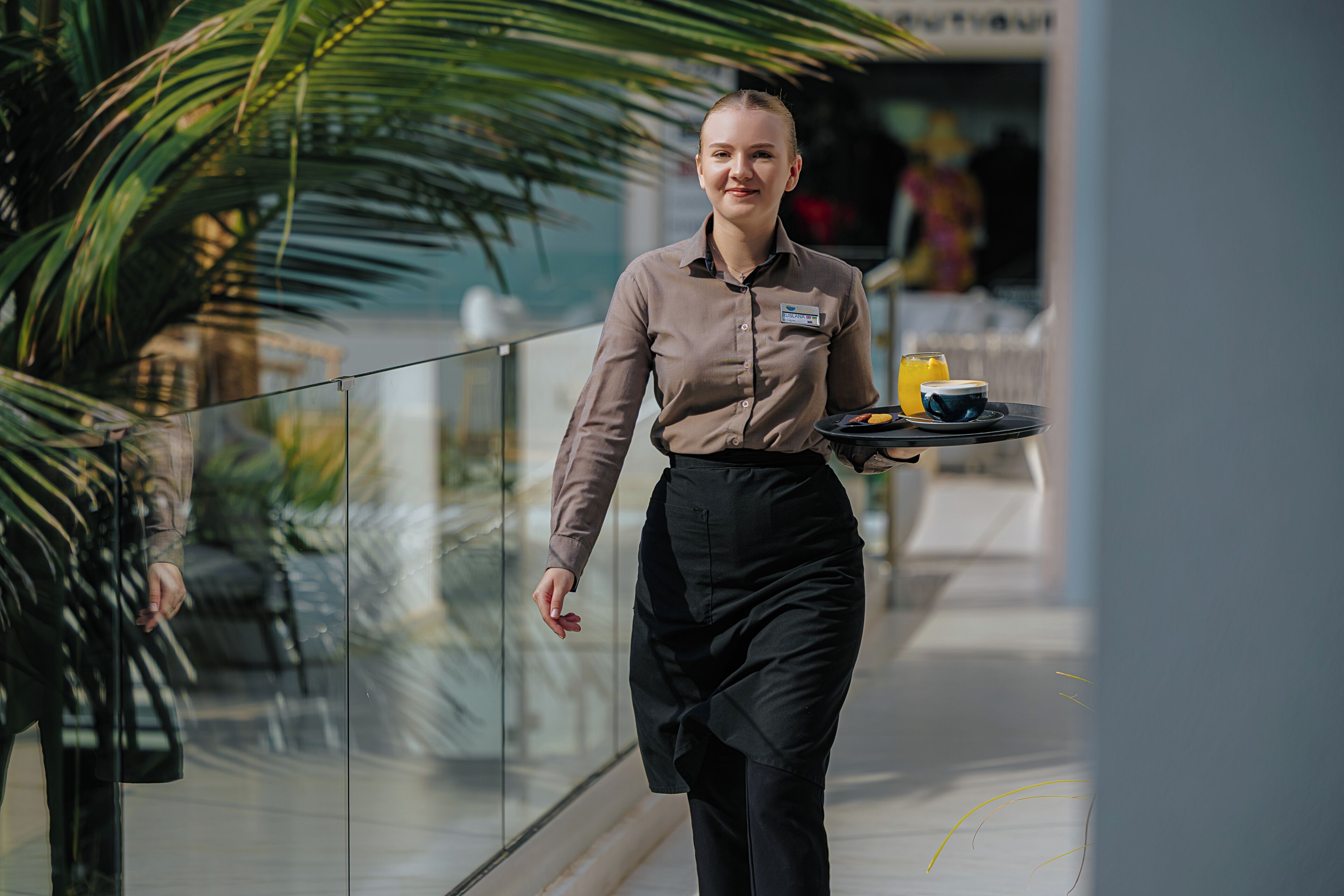 A person walking with a tray of food and drinks.