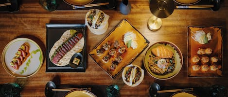 A dining table with various dishes, chopsticks, and bowls.