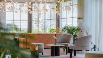 Un intérieur moderne avec un canapé, des fauteuils, une table basse et des lampes sphériques suspendues.