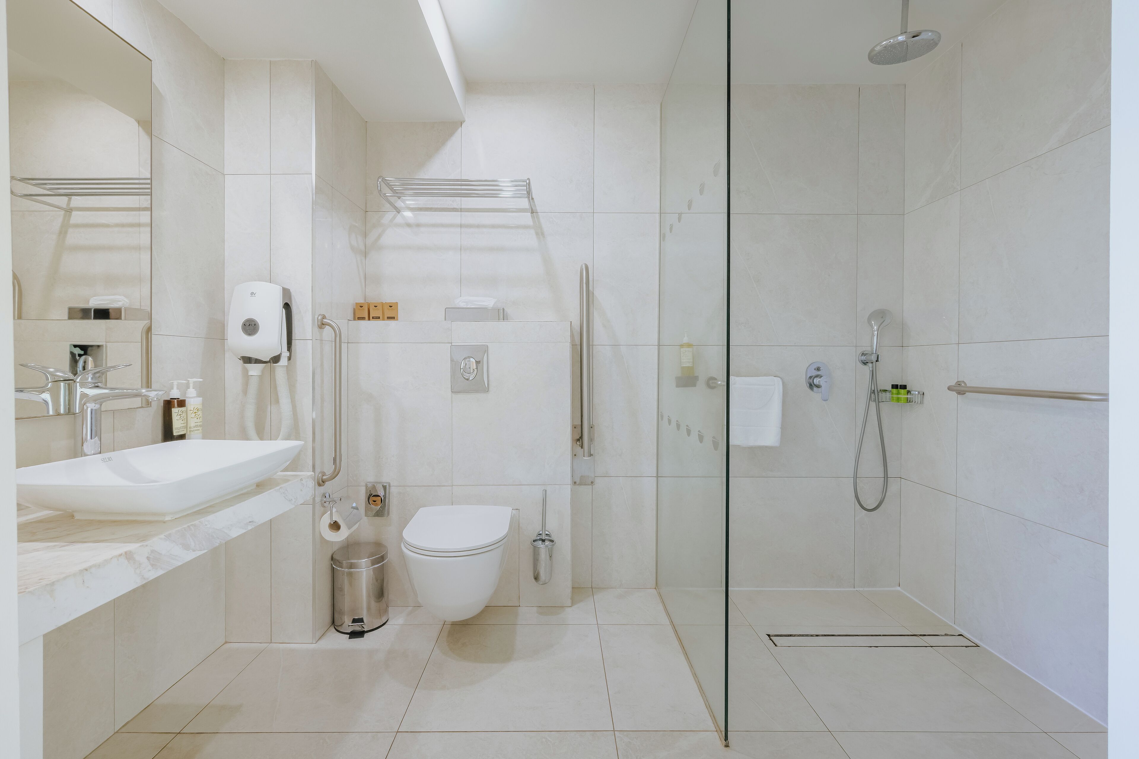A modern bathroom with a glass-enclosed shower, a white sink, and a toilet.