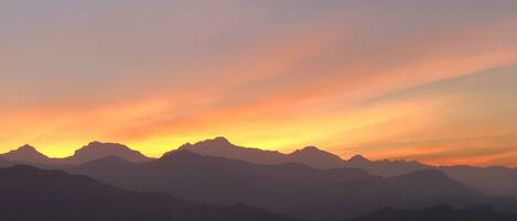 A mountain range silhouette against a sunset sky.