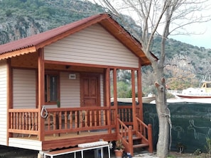 Eine Holzhütte mit Veranda, einer Tür und einem Fenster.