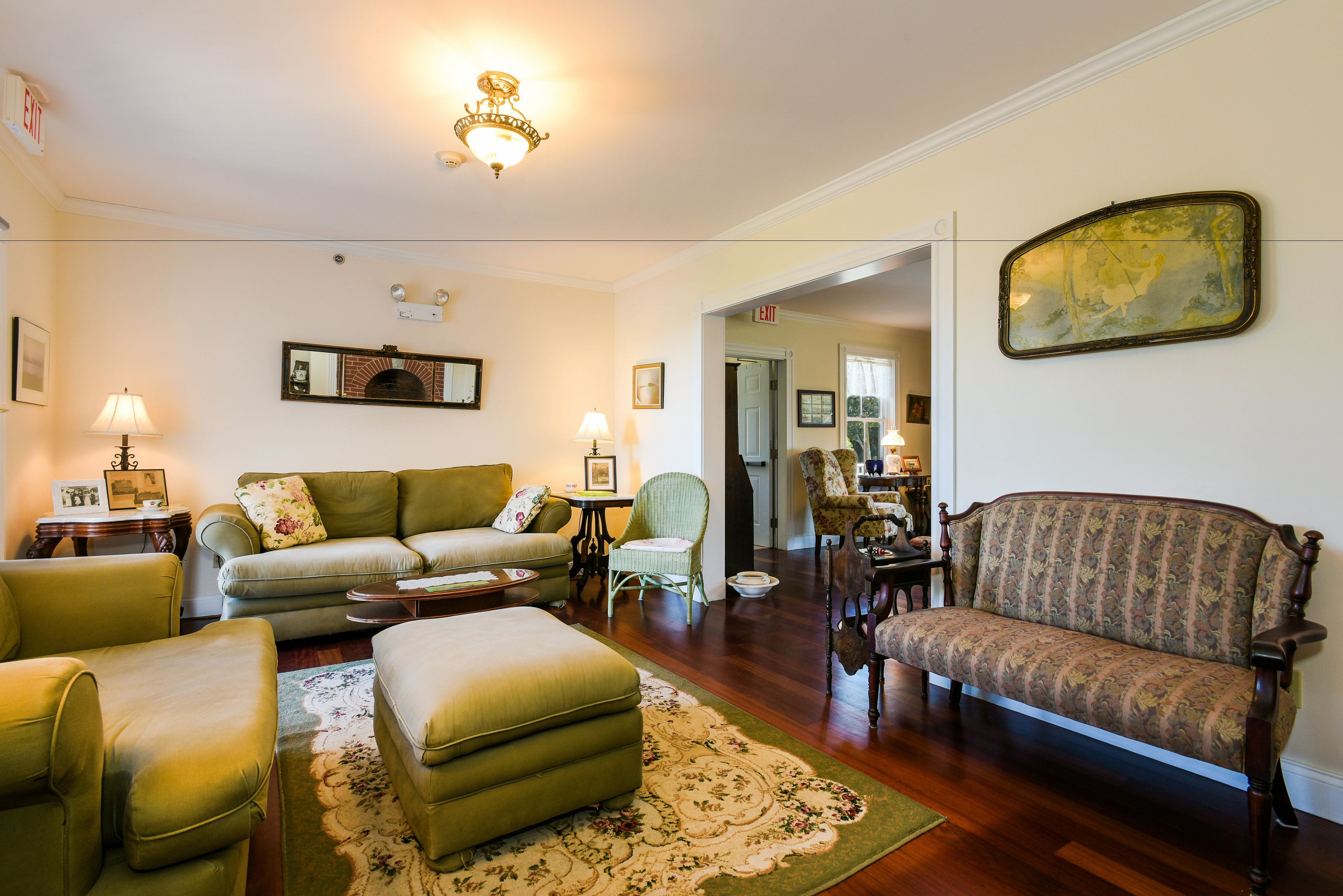 A traditional living room with a sofa, armchairs, a coffee table, and a patterned rug.