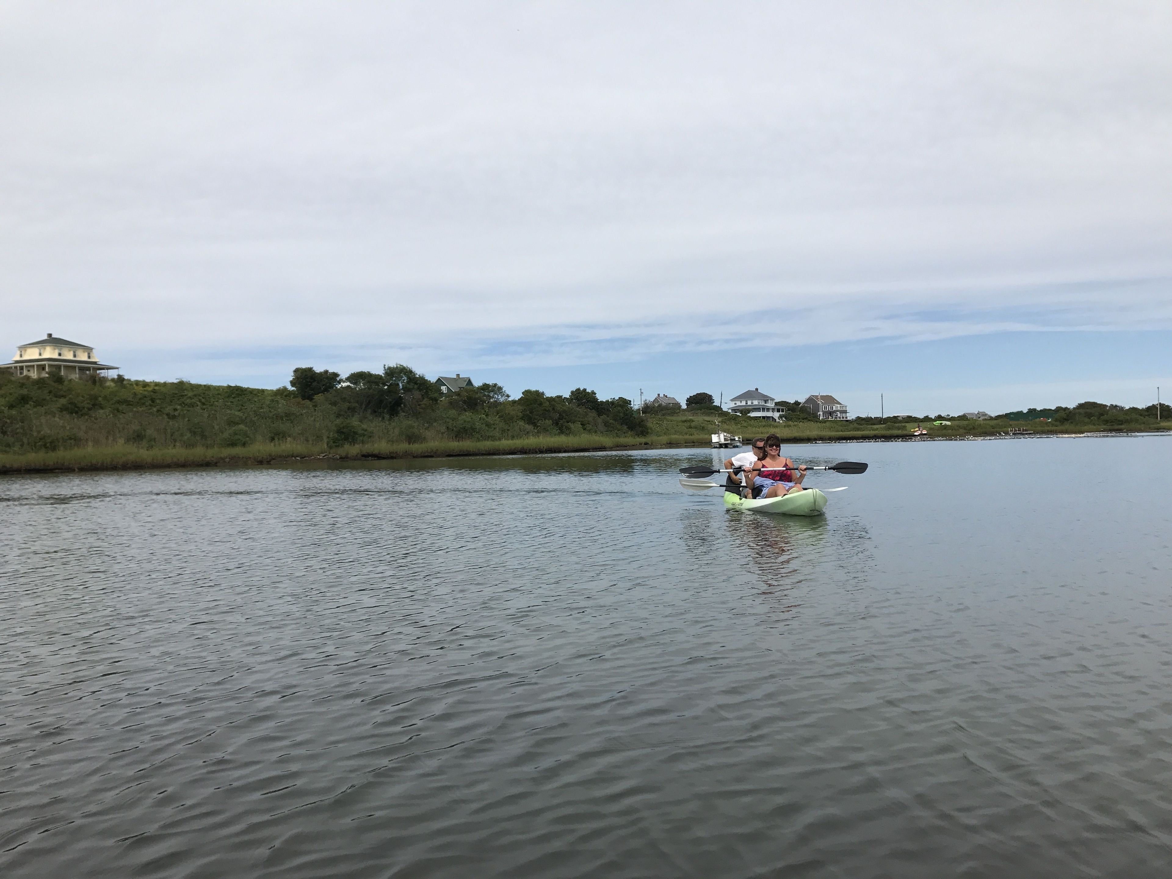 A calm river with a kayak in the foreground.