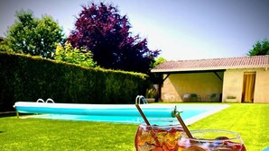 A poolside table with two glasses of iced tea and a cap with a logo. - Hôtel Restaurant Le Mont Brouilly (Quincie-en-Beaujolais)